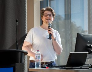 A man with glasses holding a microphone.