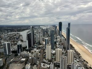 A coastal city skyline with various architectural styles and a river running through the city.